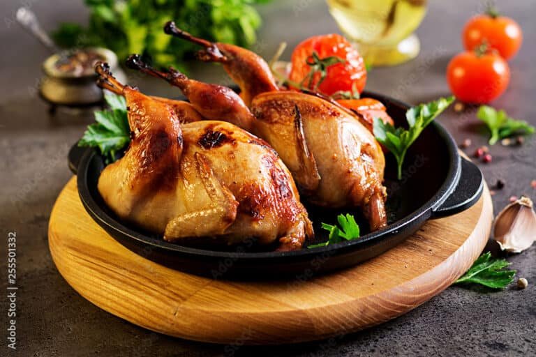 Baked quails in pan on a dark background