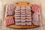 Turkish uncooked Meatballs Kofte or Kofta made with Minced Meat on Wooden Surface. Different kinds of turkish traditional meal Kofte on a light cutting.
